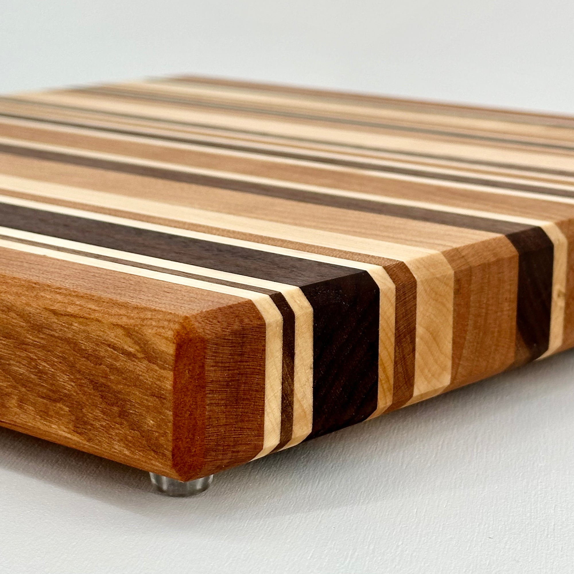 Wooden cutting board with striped pattern on a light gray background