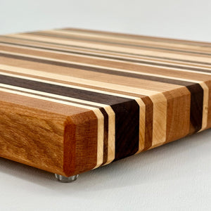 Wooden cutting board with striped pattern on a light gray background