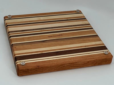 Wooden cutting board with striped pattern on a white background. Back side.